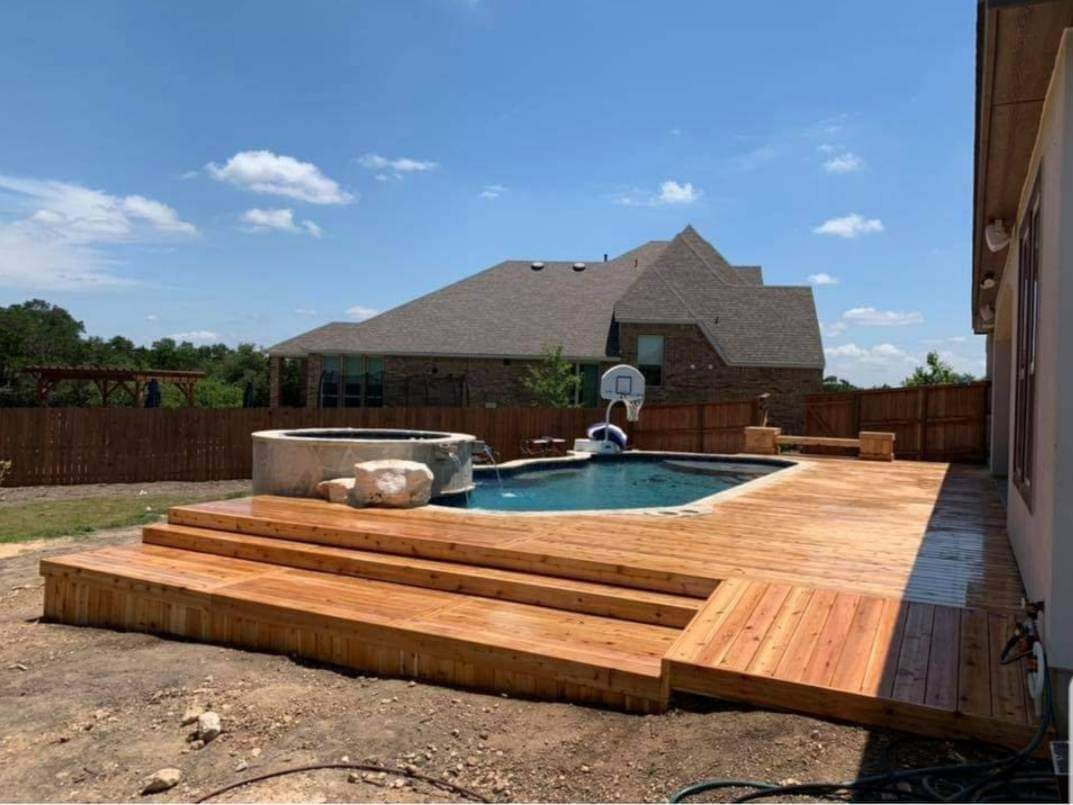 Finished backyard deck with stained wood planks by Against the Grain Woodworks